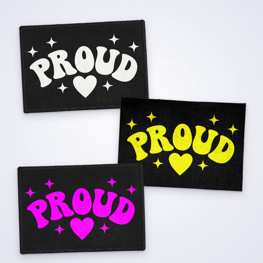 Custom screen printed sew-on patches reading Proud with a heart, in white, yellow and pink ink on black