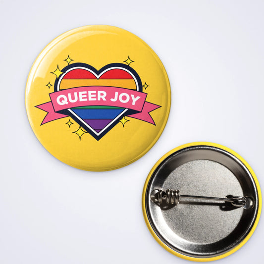 One custom pin badge with a rainbow heart and a Queer Joy banner on yellow, shown with the pin back